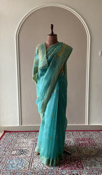 Teal organza silk saree draped on the mannequin, front view