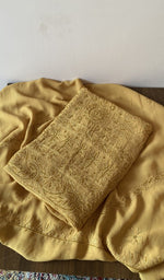 Folded yellow viscose georgette kurta piece with chikankari on the panel