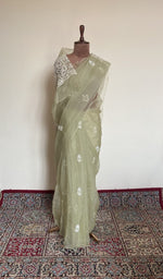 Sage green organza silk saree draped on the mannequin, front view