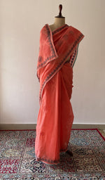 Coral Orange cotton voile chikankari saree draped on the mannequin