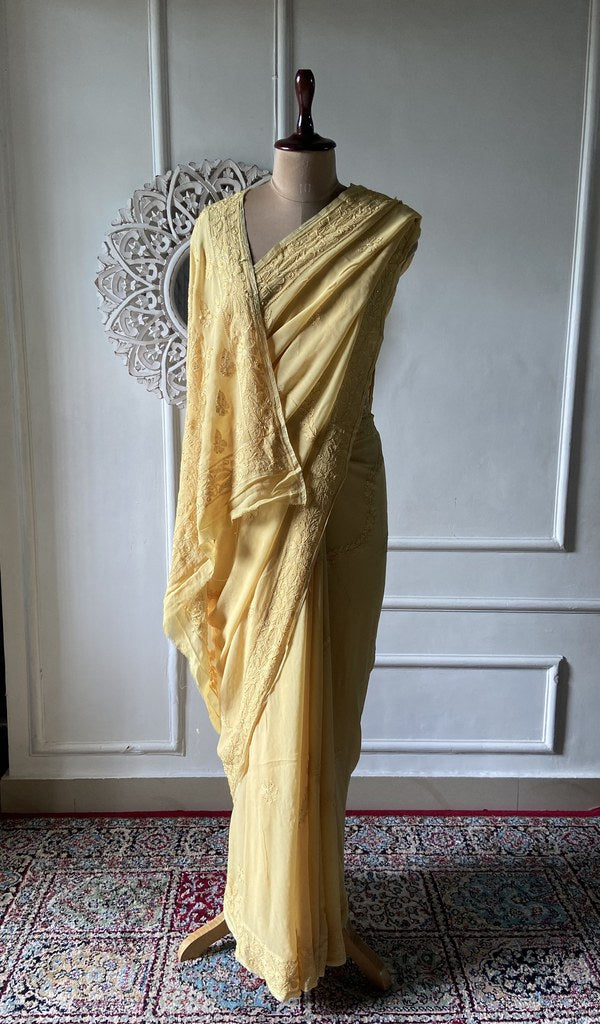 yellow viscose georgette chikankari saree draped on mannequin