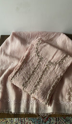 Folded pink pure mul chanderi kurta piece with chikankari in cream thread on the panel