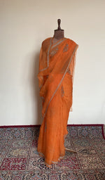Tangerine orange organza silk saree draped on the mannequin, front view
