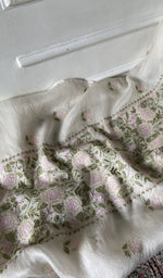 White kurta piece laid out, work across the body