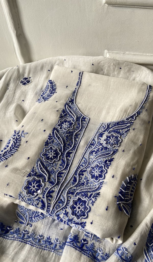 off white pure mul chanderi kurta piece folded, fine shaded blue coloured chikankari with matching beads