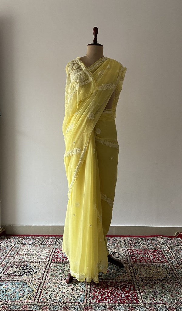 Yellow faux georgette saree draped on the mannequin