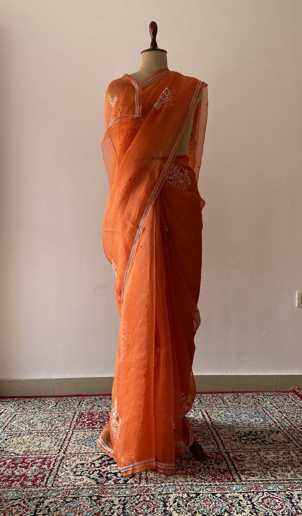 Orange pure organza silk saree draped on the mannequin