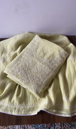 Folded yellow pure mul chanderi kurta piece with chikankari on the panel