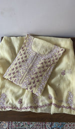 Folded yellow pure mul chanderi kurta piece with chikankari in lilac thread on the panel