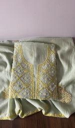 Folded green pure mul chanderi kurta piece with chikankari in gold thread on the panel