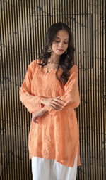 Orange short kurti, worn by the model