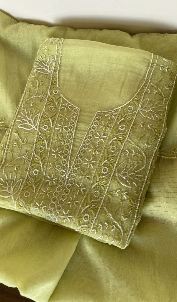 Lime green pure mul chanderi kurta piece folded, fine chikankari on the panel, along with beads