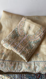 Folded beige pure organza silk kurta piece with chikankari on the panel