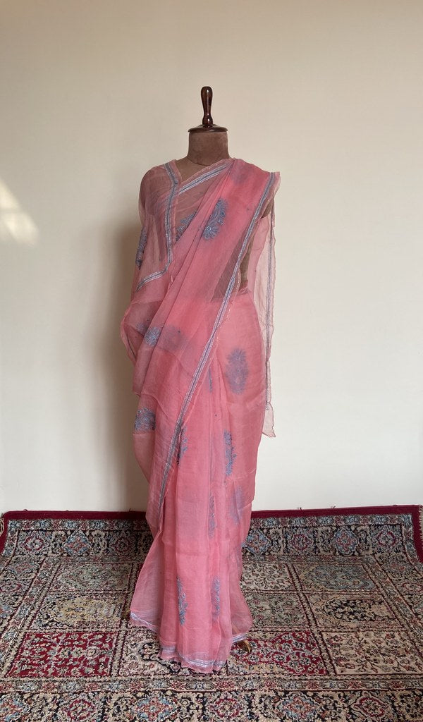 Coral pink organza silk saree draped on the mannequin, front view